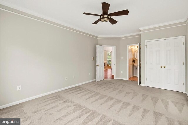  - unfurnished bedroom featuring carpet floors, crown molding, ensuite bathroom, and ceiling fan