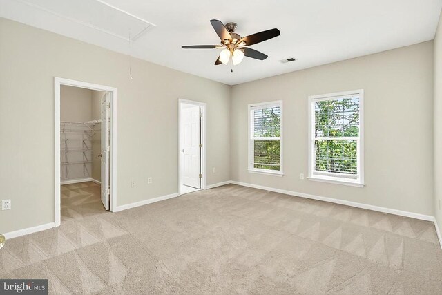  - unfurnished bedroom with attic access, carpet floors, and a ceiling fan