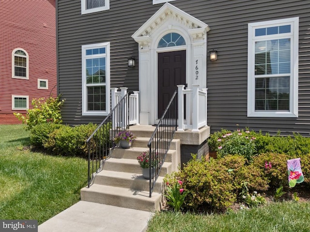  - property entrance featuring a lawn