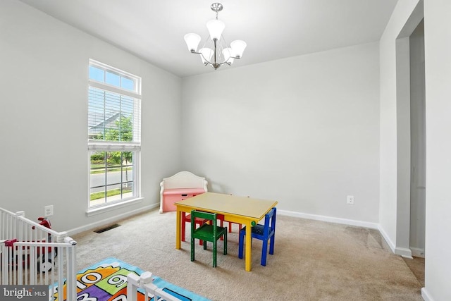  - rec room featuring carpet floors, healthy amount of natural light, and a chandelier