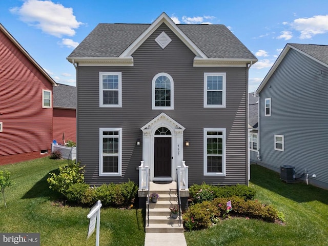  - colonial home with a front yard and a shingled roof