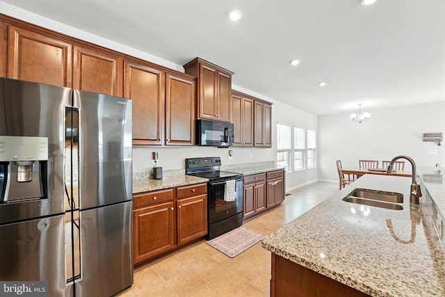  - kitchen with black appliances, a chandelier, light stone countertops, brown cabinetry, and recessed lighting