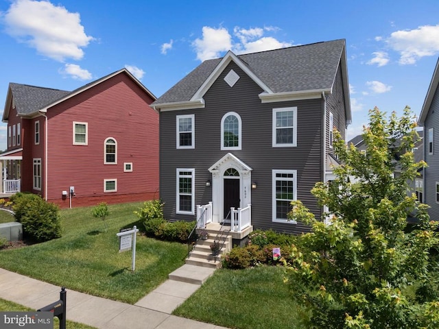  - colonial inspired home with a front lawn and a shingled roof