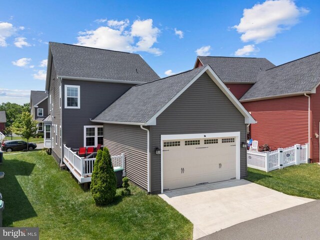  - view of side of property featuring an attached garage, a shingled roof, and driveway