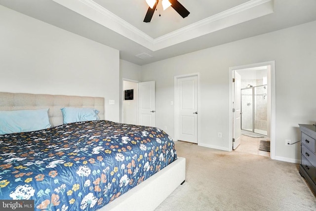  - carpeted bedroom with crown molding, connected bathroom, a tray ceiling, and ceiling fan