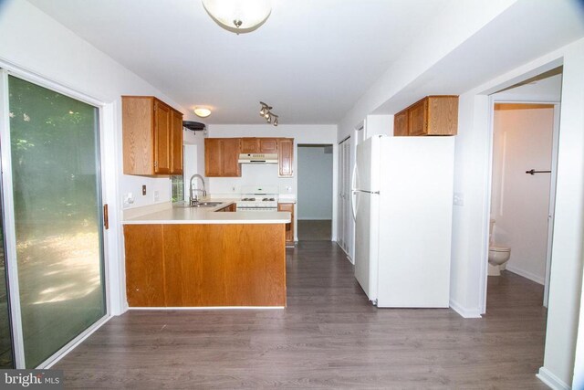 5903 Vista Ct, Fredericksburg, VA 22407 - kitchen with white appliances, under cabinet range hood, a sink, brown cabinetry, and a peninsula