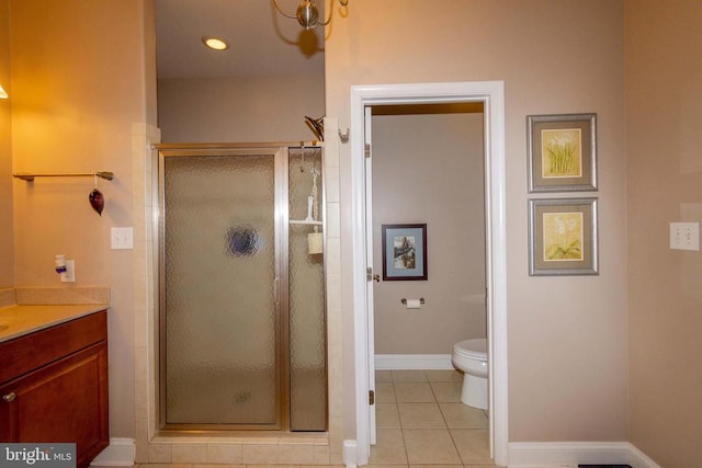full bathroom featuring toilet, baseboards, tile patterned flooring, a shower stall, and vanity