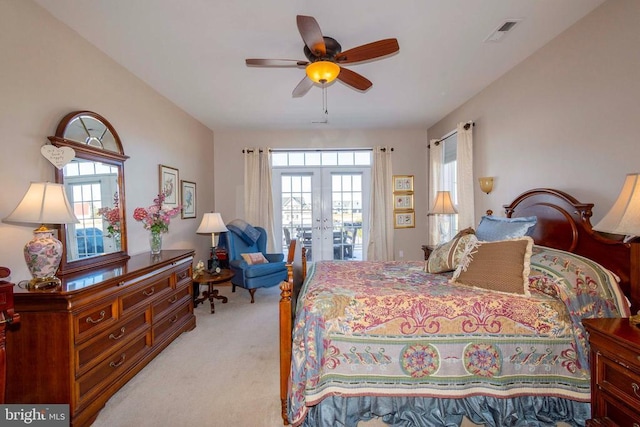 bedroom with light colored carpet, multiple windows, visible vents, and french doors