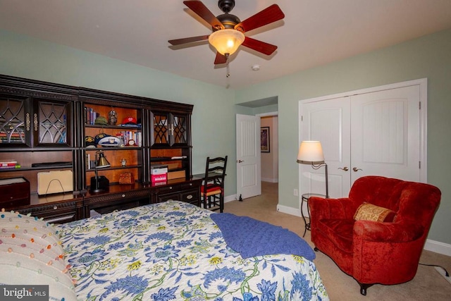 carpeted bedroom with baseboards, a closet, and ceiling fan