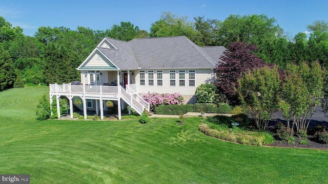 rear view of property with a lawn, stairway, roof with shingles, and covered porch