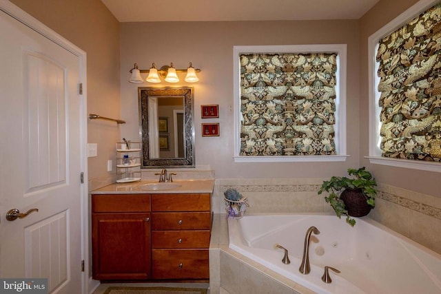 bathroom with a tub with jets and vanity