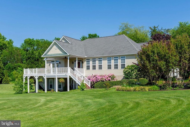 back of property featuring stairs, a yard, a wooden deck, a ceiling fan, and a shingled roof