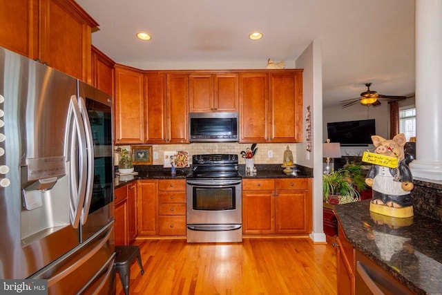 kitchen featuring a ceiling fan, brown cabinetry, backsplash, light wood-style floors, and stainless steel appliances