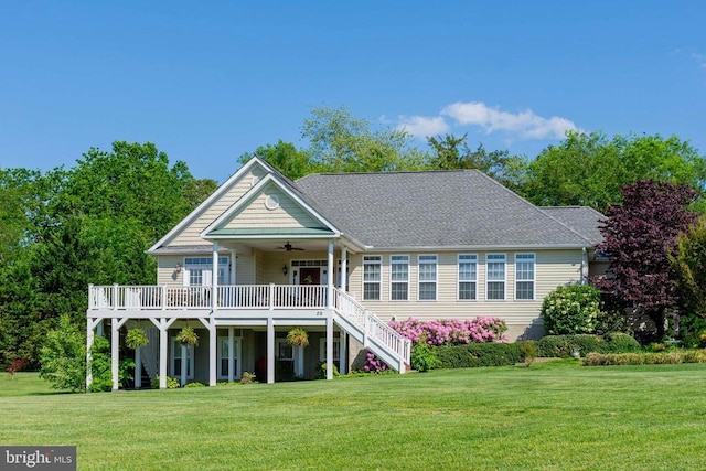 rear view of property with a lawn, a wooden deck, and a ceiling fan