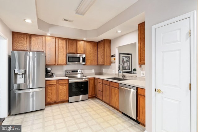 11313 Macon Dr, Fredericksburg, VA 22407 - kitchen featuring stainless steel appliances, light countertops, light flooring, brown cabinetry, and recessed lighting
