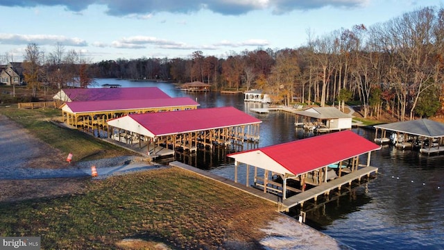 view of dock with a water view, a lawn, and boat lift