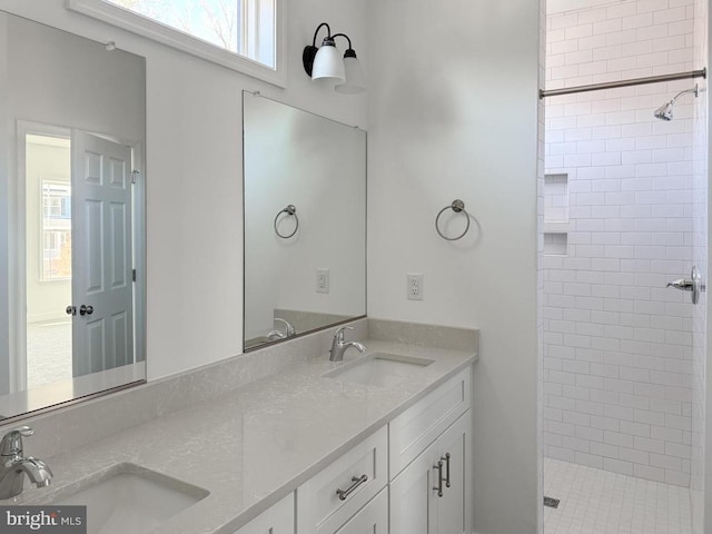 bathroom with tiled shower and vanity