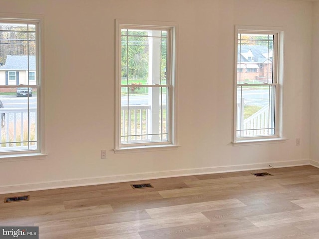 empty room with a healthy amount of sunlight and visible vents