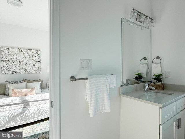 bathroom with baseboards, toilet, ensuite bath, wood finished floors, and vanity