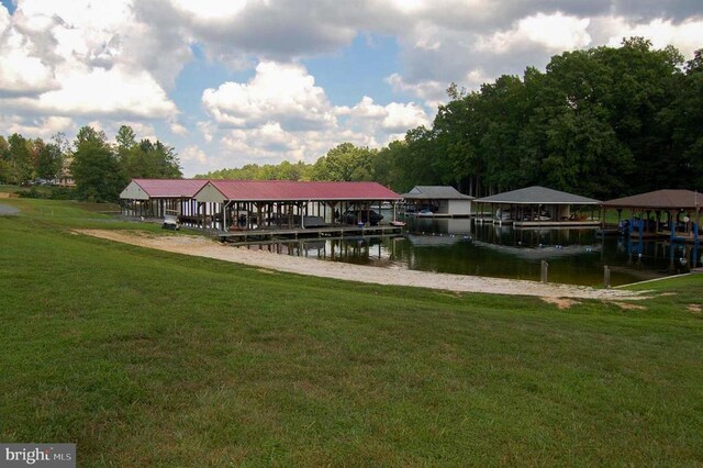 view of dock with a water view and a yard