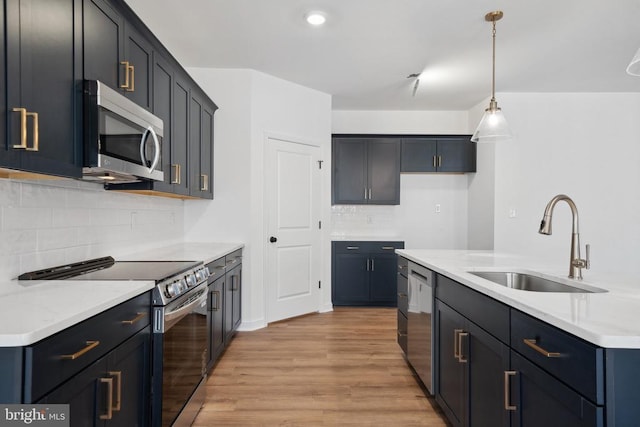 201 Zion Manor Rd Lot 13, Gordonsville, VA 22942 - kitchen with appliances with stainless steel finishes, a sink, light wood-style floors, decorative backsplash, and hanging light fixtures