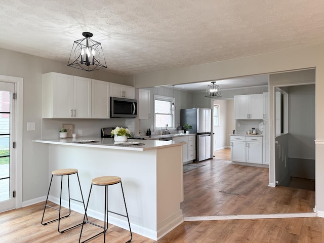 6 Maple Dr, Verona, VA 24482 - kitchen featuring stainless steel appliances, a chandelier, a peninsula, a textured ceiling, and white cabinets