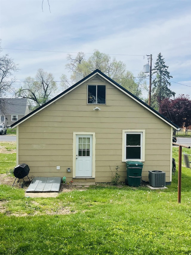 back of house with central AC and a yard