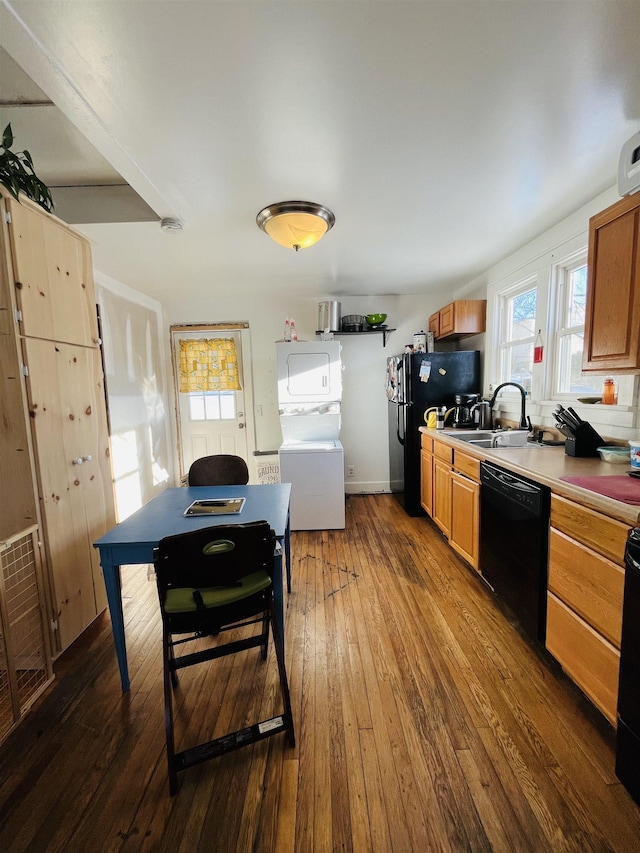 kitchen with brown cabinetry, dark wood-style floors, a sink, and black appliances
