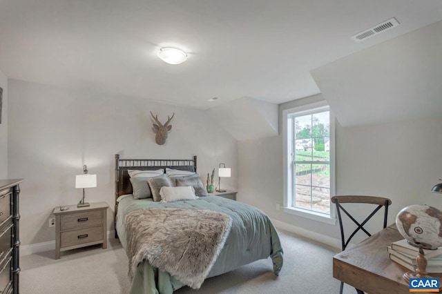 bedroom featuring light colored carpet, lofted ceiling, baseboards, and visible vents
