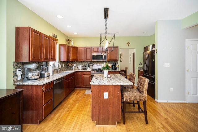 6733 Averett Ct, Fredericksburg, VA 22407 - kitchen featuring a kitchen breakfast bar, tasteful backsplash, light wood-type flooring, and appliances with stainless steel finishes