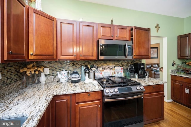 6733 Averett Ct, Fredericksburg, VA 22407 - kitchen with appliances with stainless steel finishes, tasteful backsplash, light stone countertops, and light wood-style floors