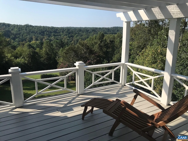 wooden terrace featuring a forest view
