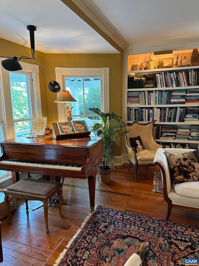 living area with a wealth of natural light, crown molding, and wood-type flooring