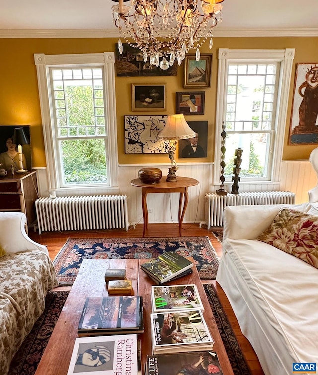 sitting room with a chandelier, radiator heating unit, and ornamental molding