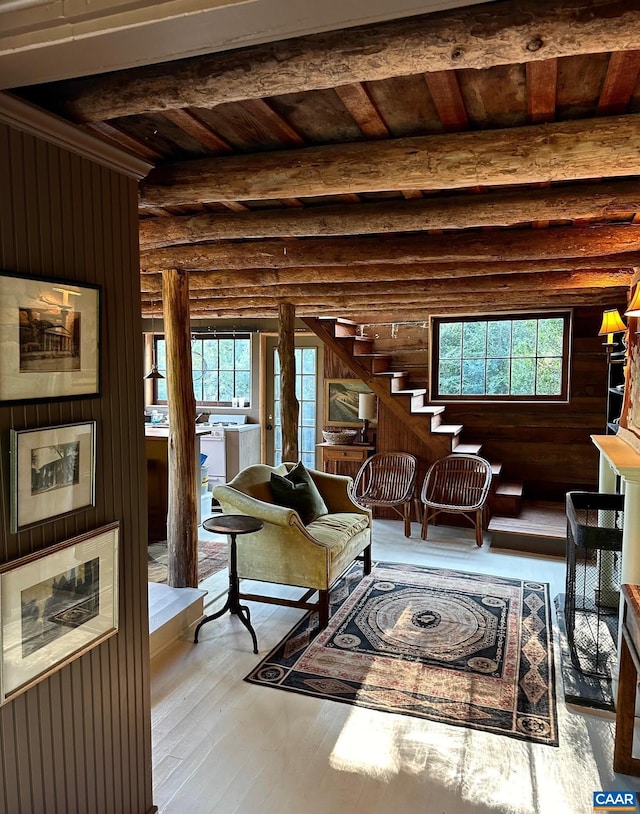 living area with wood ceiling, beam ceiling, hardwood / wood-style flooring, and log walls