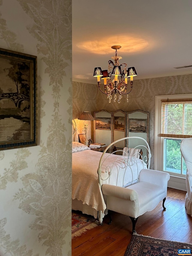 bedroom featuring a chandelier, wallpapered walls, and wood-type flooring