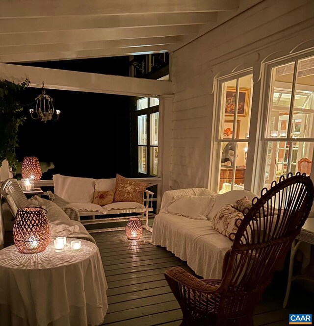 living room with beam ceiling, hardwood / wood-style flooring, and a notable chandelier