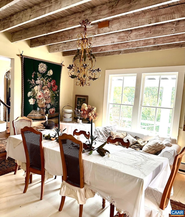 dining space with beam ceiling, wood finished floors, and a healthy amount of sunlight
