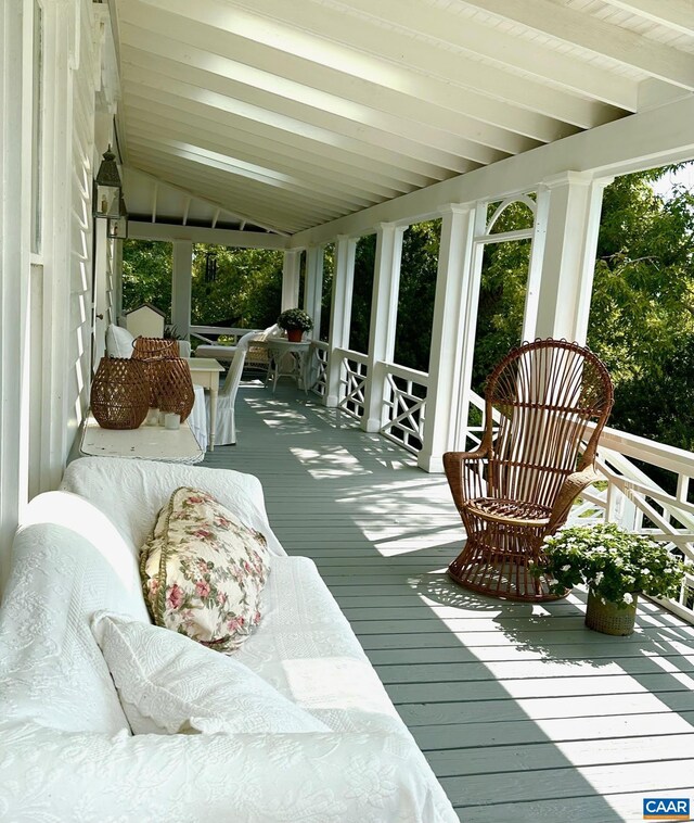 sunroom with vaulted ceiling with beams and hardwood / wood-style flooring