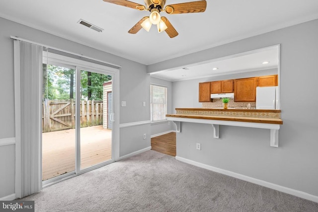 11260 Girven Ct, Fredericksburg, VA 22407 - kitchen featuring freestanding refrigerator, under cabinet range hood, carpet flooring, a breakfast bar, and ceiling fan