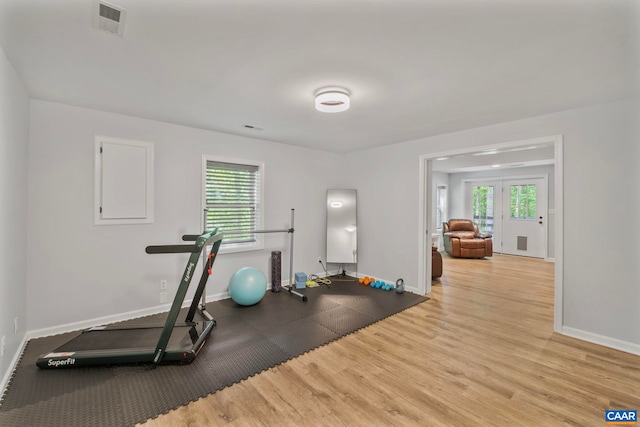 exercise room with wood finished floors and baseboards