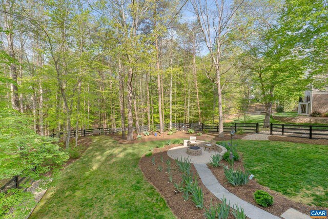 view of yard featuring an outdoor fire pit and a patio