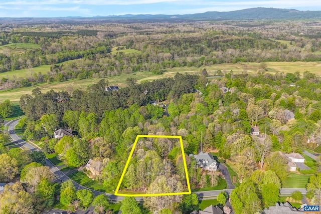 aerial view of property and surrounding area featuring a forest and property parcel outlined