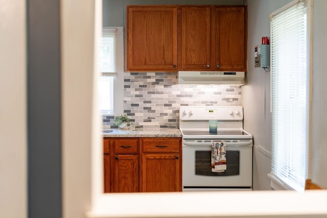 143 Pkin Ln, Raphine, VA 24472 - kitchen with under cabinet range hood, white electric range, decorative backsplash, and healthy amount of natural light