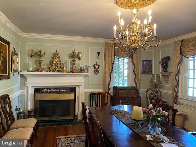  - dining room featuring a fireplace, crown molding, a chandelier, and wood finished floors