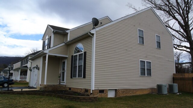 view of property exterior featuring a garage, central AC, a lawn, and fence