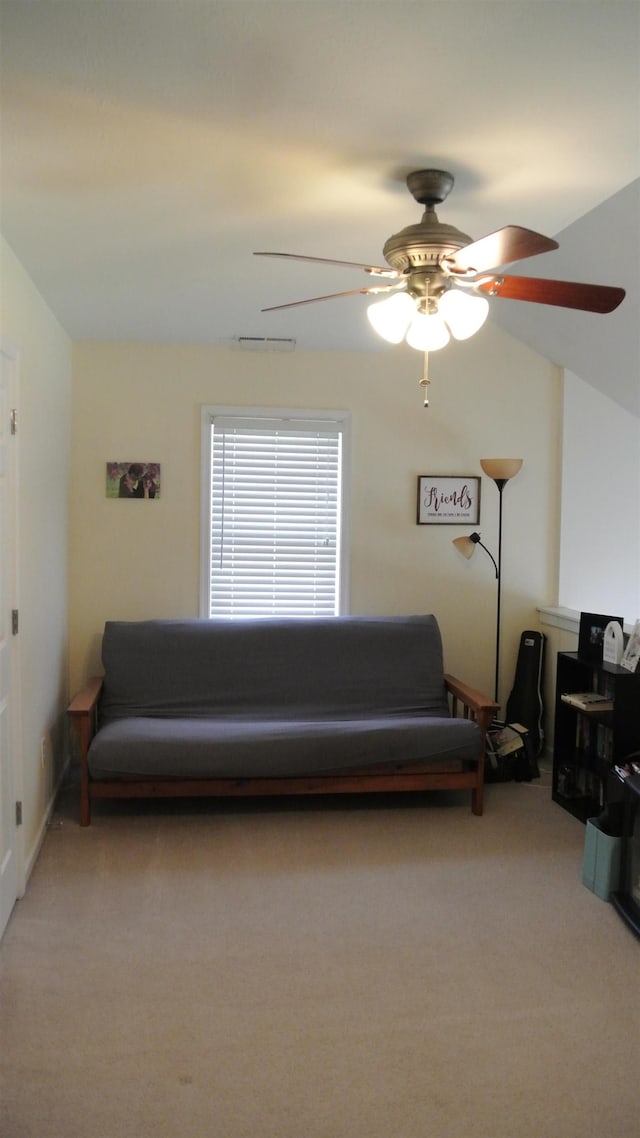 living area featuring a ceiling fan, light colored carpet, vaulted ceiling, and visible vents