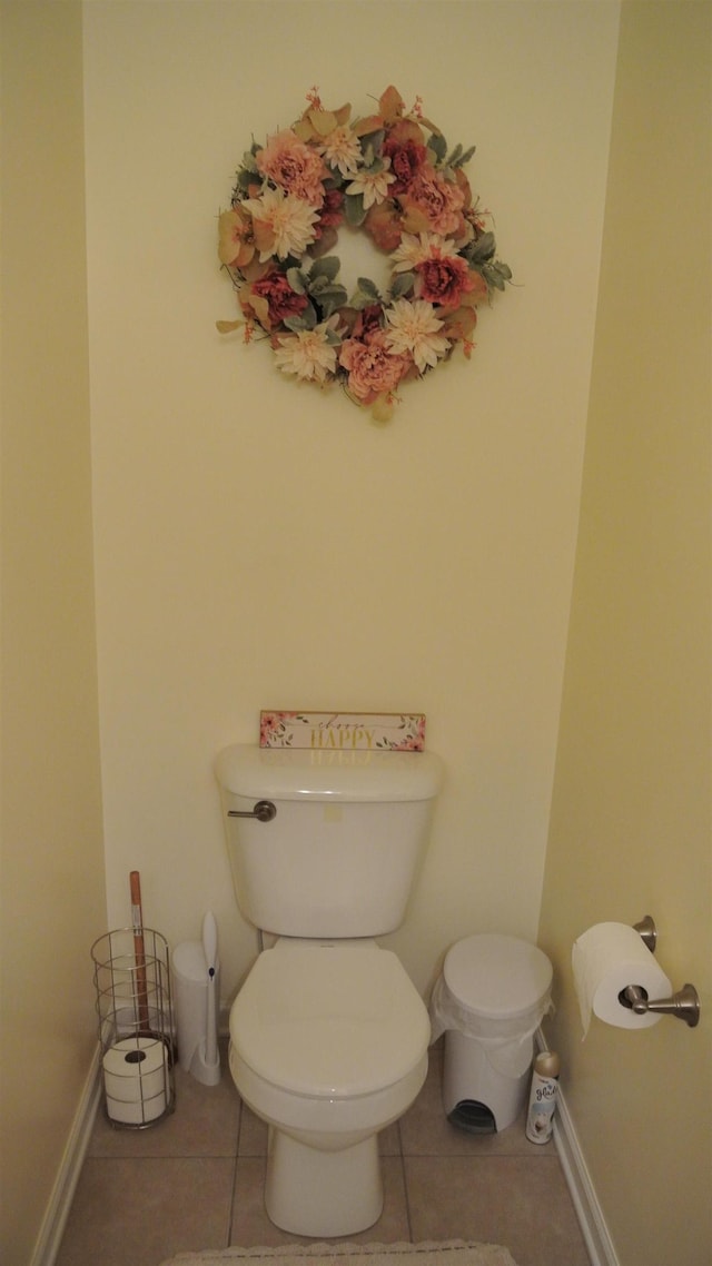 bathroom with tile patterned flooring, toilet, and baseboards