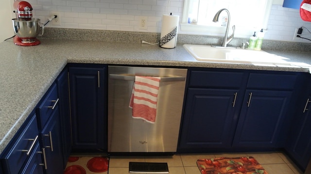 kitchen featuring stainless steel dishwasher, decorative backsplash, a sink, and blue cabinets