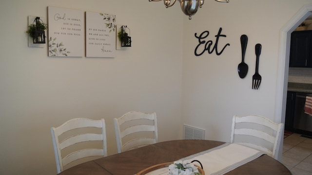 dining space featuring light tile patterned flooring, visible vents, and an inviting chandelier